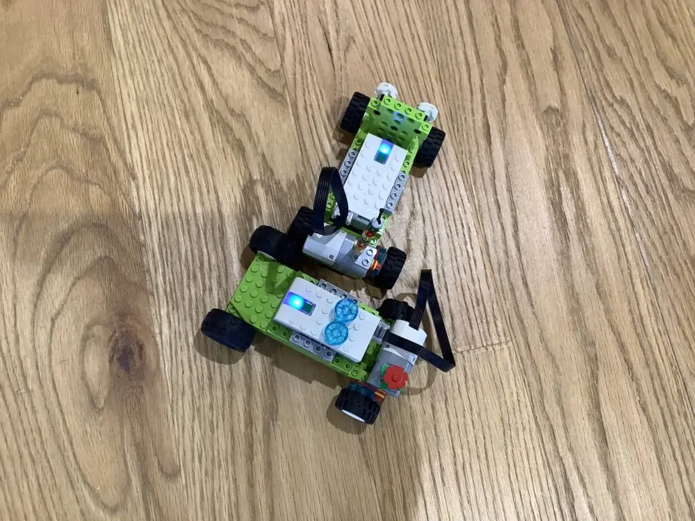 教室でブロックを組み立て、タブレットでプログラミングする子どもたちの様子